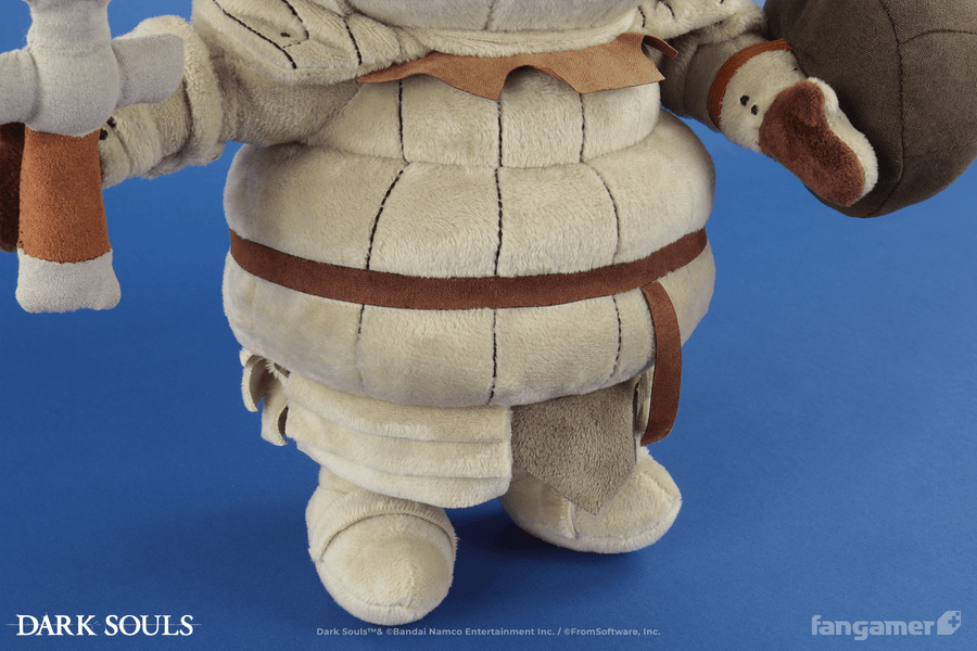 A closeup of the body of the Siegmeyer plush, showing its legs, fabric belt, and multilayer plush armor details, as well as its sword and shield accessories. - Siegmeyer Plush - DARK SOULS